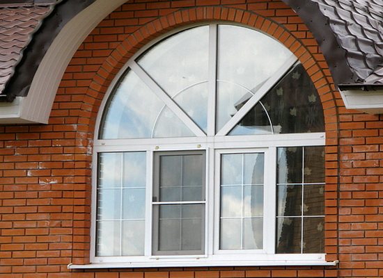 Fenêtre en plastique cintrée dans une maison en brique