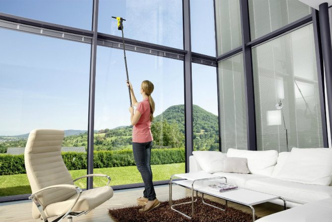 Une longue brosse ou une éponge magnétique est utilisée pour nettoyer les grandes fenêtres panoramiques