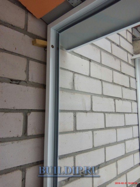 Photo de la fixation du cadre du balcon latéral du vitrage à froid.