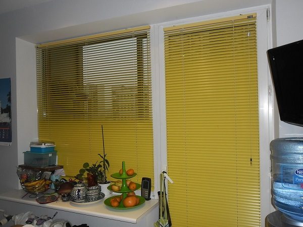stores horizontaux sur une fenêtre avec une porte de balcon