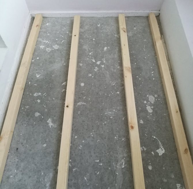 Protokolle unter einem Holzboden auf dem Boden der Loggia