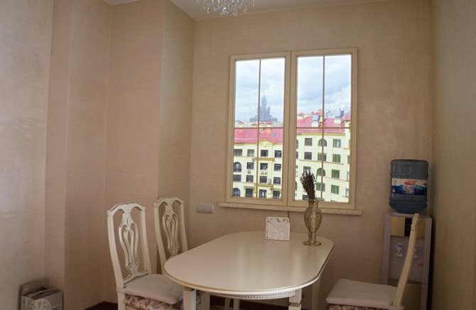 Coin repas devant une fausse fenêtre sur le mur de la cuisine