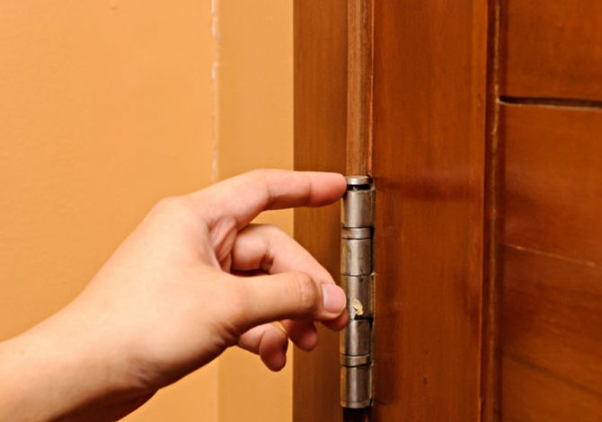 Dobradiças em uma porta de madeira