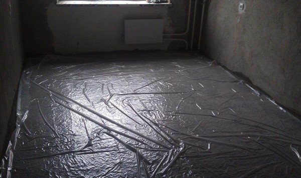 The film is laid out on the surface of the floor with fixation in the corners using double-sided tape