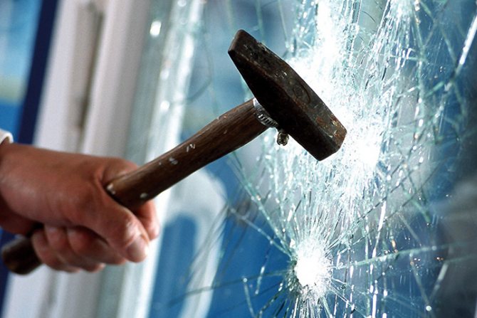Prüfung der Festigkeit des Fensters mit einem Hammer