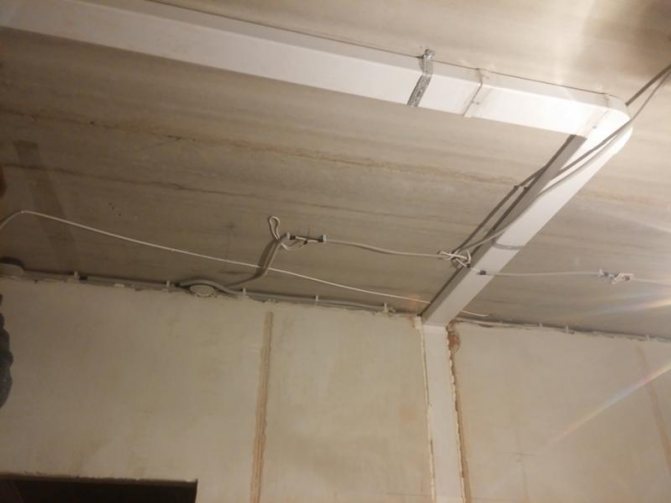 Des conduits rectangulaires sont fixés au plafond en béton.