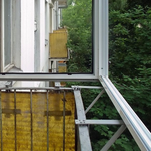 installation de cadres en aluminium sur un balcon avec un plat à emporter