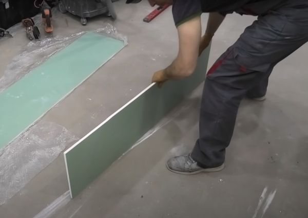 Alignement du bord coupé d'une feuille de cloison sèche.